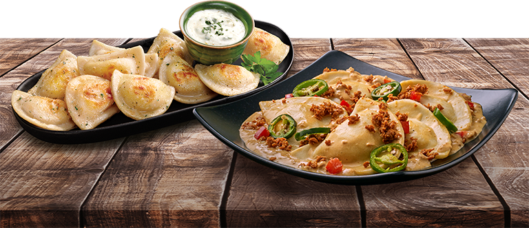 Two dishes of pierogies on a wooden tabletop